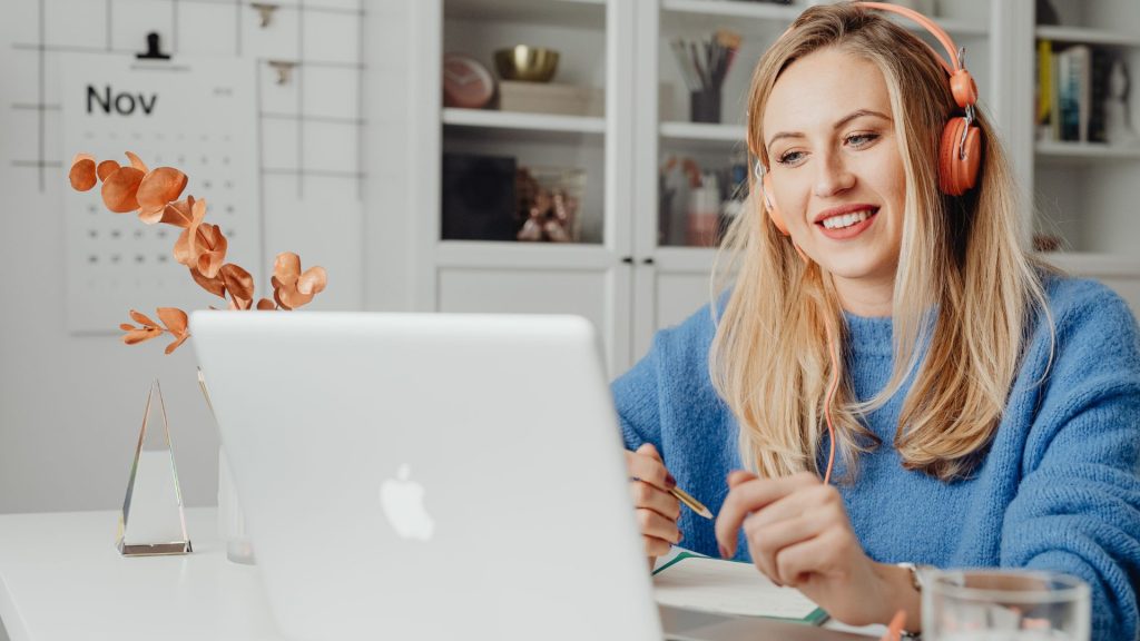 Donna che lavora al computer con cuffie durante un’attività di formazione online, simbolo della sperimentazione e dell’esplorazione di nuove direzioni professionali